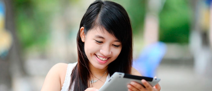 A female student looks at her tablet. 